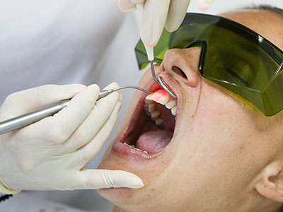 A person receiving dental care with a dentist using a drill on their teeth.