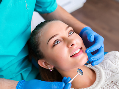 A dental hygienist performing a teeth cleaning procedure on a patient.