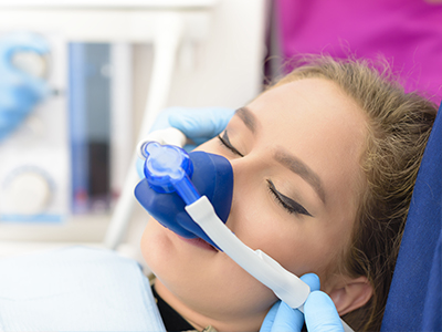 The image shows a person receiving oxygen therapy with a medical device, likely in a hospital setting, as indicated by the presence of medical equipment and personnel.